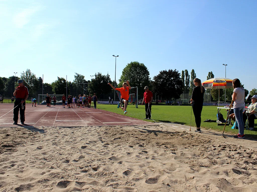 Blick über die Sprunganlage auf den Sportplatz.